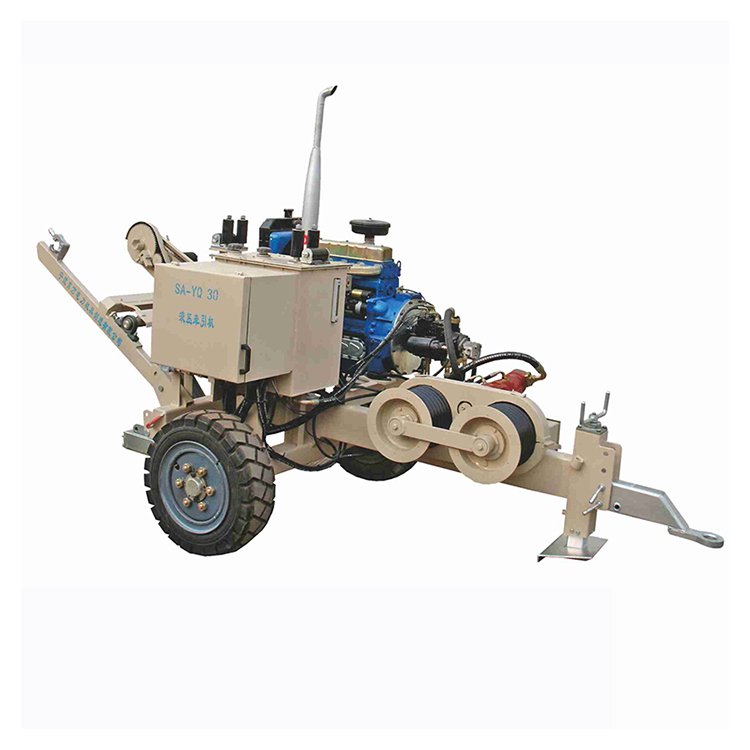 Trailer-mounted hydraulic cable pulling winch with blue engine, beige body, large wheels, and dual pulleys for power line work