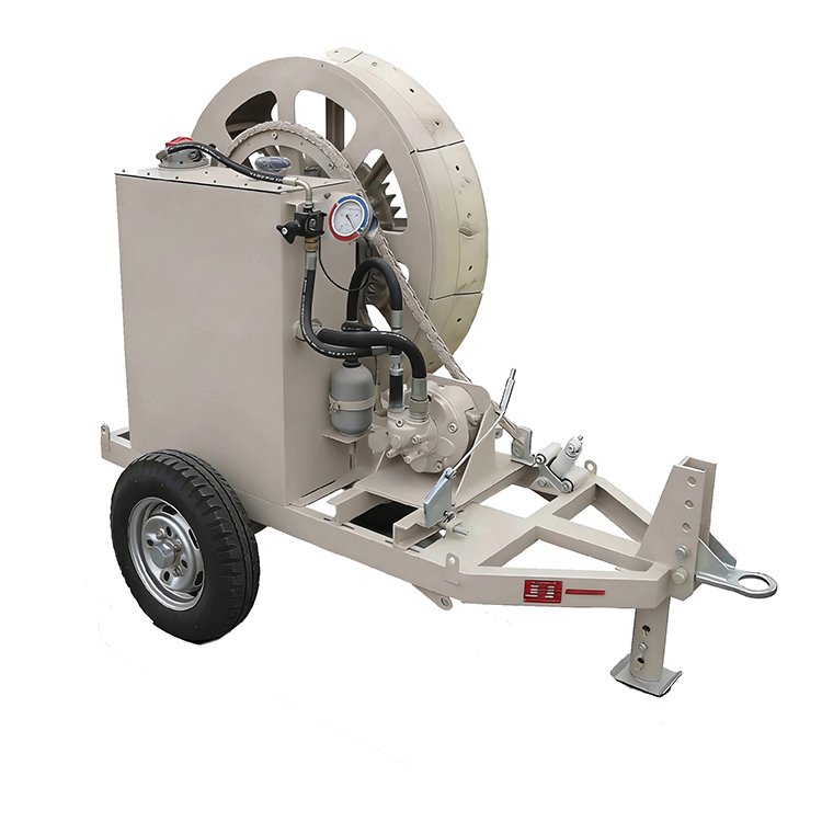 Portable hydraulic cable pulling winch on a single-axle trailer with control gauges, hydraulic hoses, and a large cable spool.